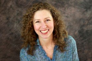 Headshot in blue, smiling